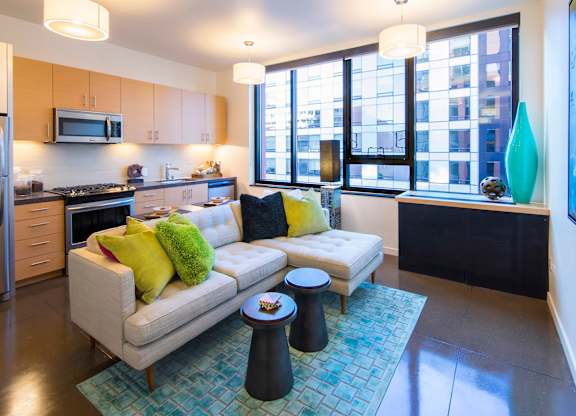 A modern kitchen with a white couch and a blue rug.