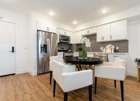 A modern kitchen with a dining table and chairs.