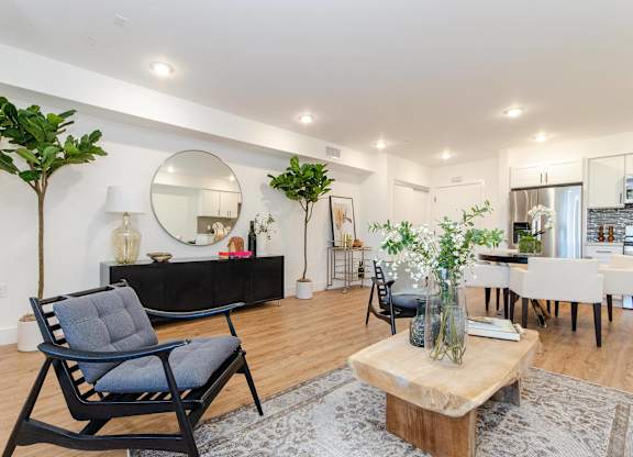 A living room with a black chair and a wooden coffee table.