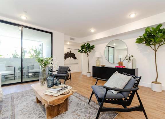 A living room with a black chair and a wooden coffee table.