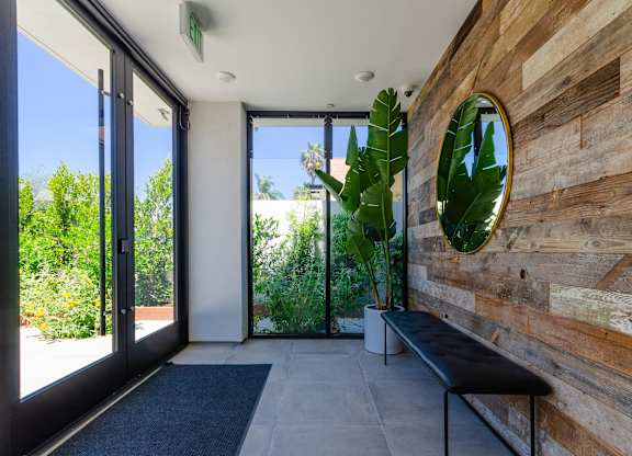 A wooden wall with a mirror and bench in front of it.