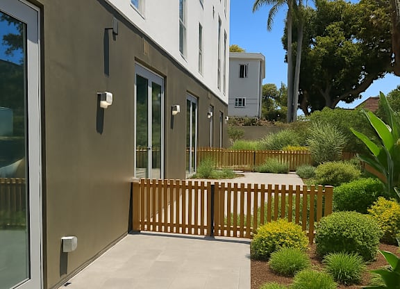 A modern house with a wooden fence and a garden in front.