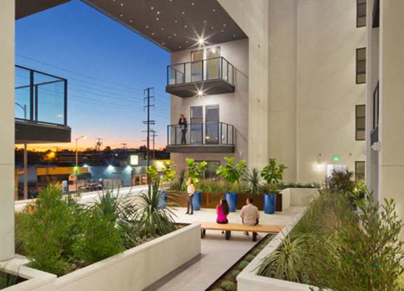A modern courtyard with a bench and plants.