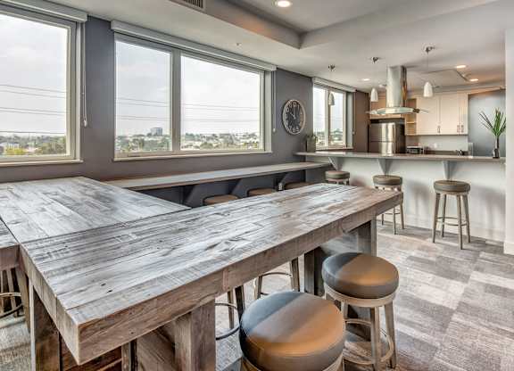 A kitchen with a large wooden table and bar stools.