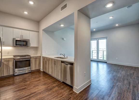 A kitchen with wood floors and a large window.