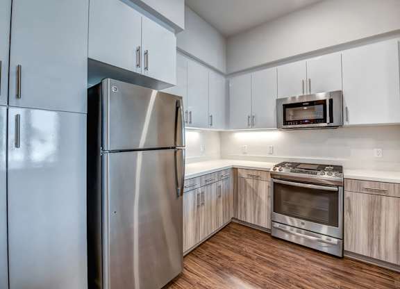 A modern kitchen with a stainless steel refrigerator and oven.
