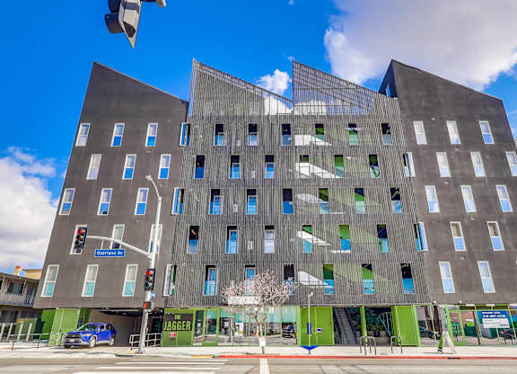 A modern building with a black facade and blue windows.