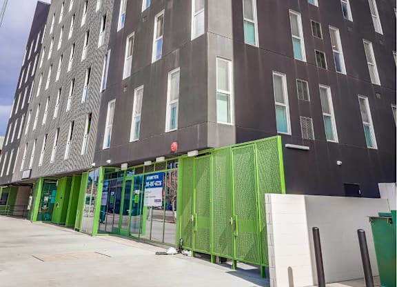 A tall building with a green door and windows.