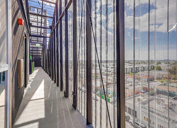 A long corridor with a view of the city through the windows.