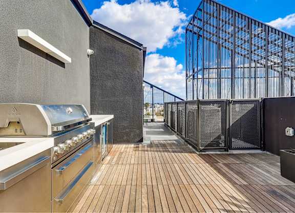 A modern outdoor kitchen with a grill and a barbecue oven.
