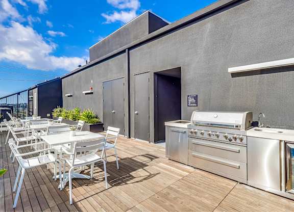 A patio with a grill and chairs.