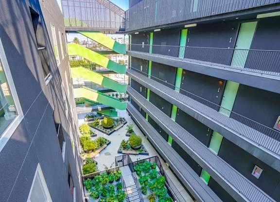A view from a high-rise building looking down at a courtyard with greenery.