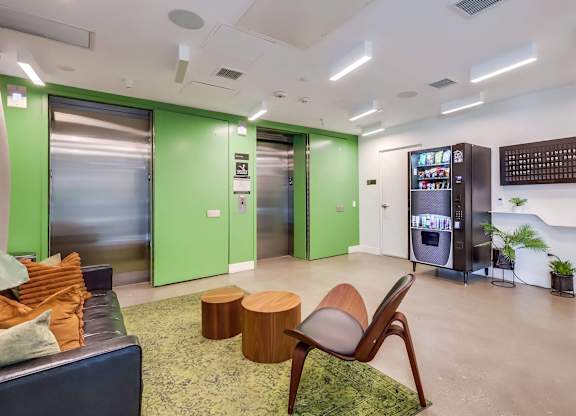 A modern office space with green walls and a wooden chair.