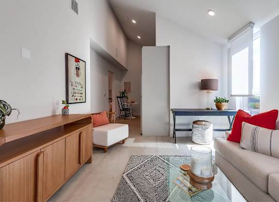 A living room with a couch, a coffee table, and a painting on the wall.