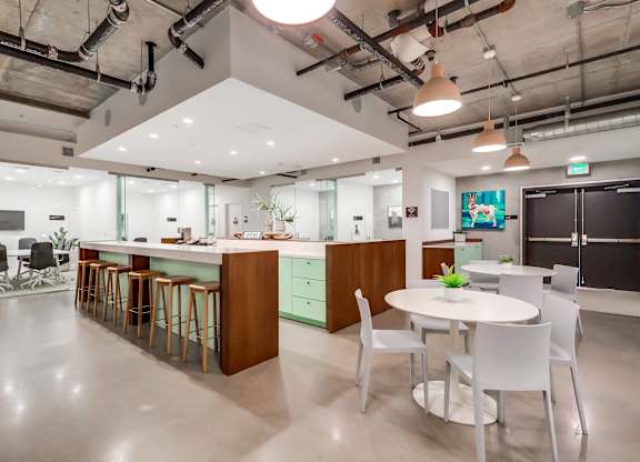 A modern kitchen with a bar area and a dining table.