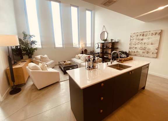 A modern kitchen with a white countertop and dark brown cabinets.