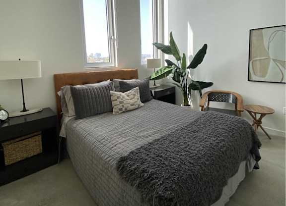 A bedroom with a large bed and a window.