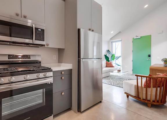 A modern kitchen with a stainless steel refrigerator and oven.