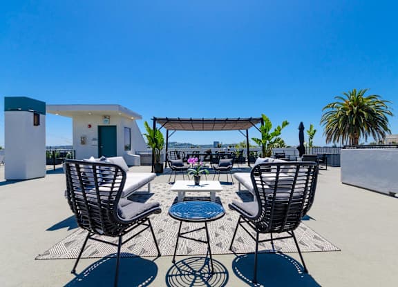 A patio with chairs and a table is set up on a sunny day.