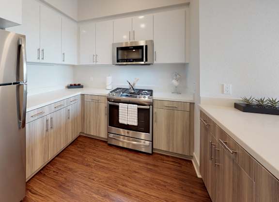 A modern kitchen with wooden cabinets and stainless steel appliances.