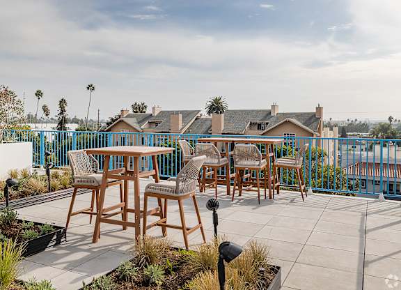 A patio with a table and chairs overlooking a street.