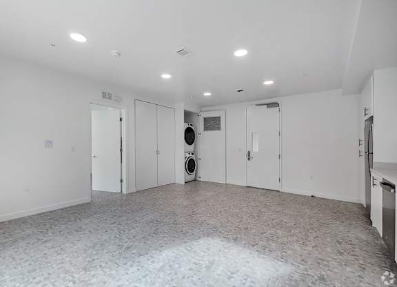 A large empty room with a tiled floor and white walls.