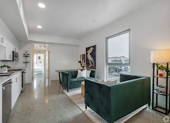 A modern kitchen with white cabinets and a green island.