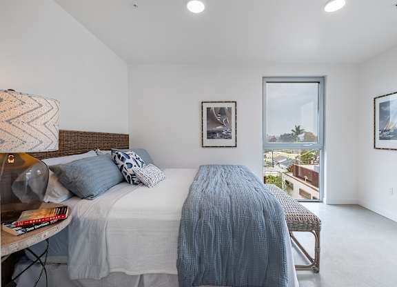 A bedroom with a large bed and a view of the outside.