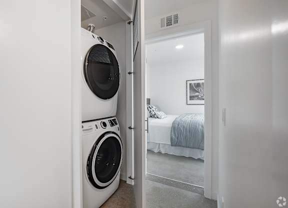 A white laundry room with a washer and dryer in it.