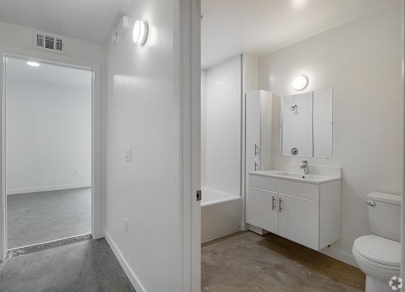 A white bathroom with a toilet, sink, and mirror.