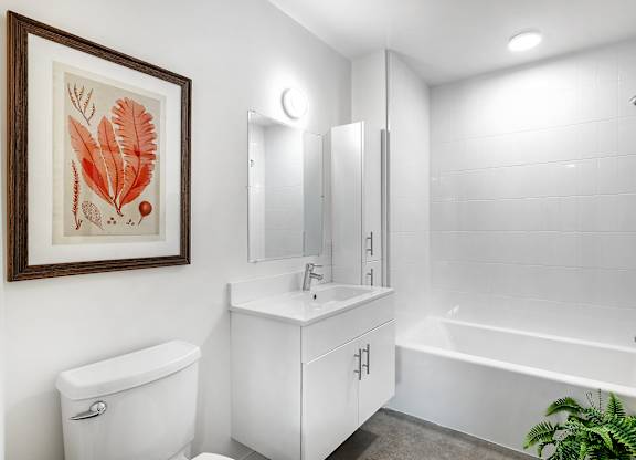 A white bathroom with a white toilet, sink, and bathtub.