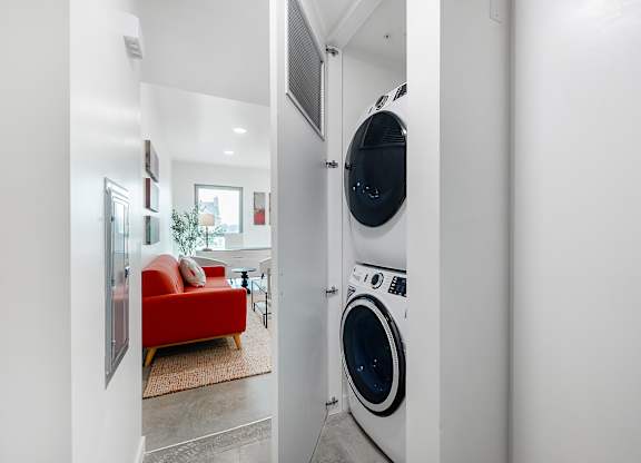A red couch is in the background of a laundry room.