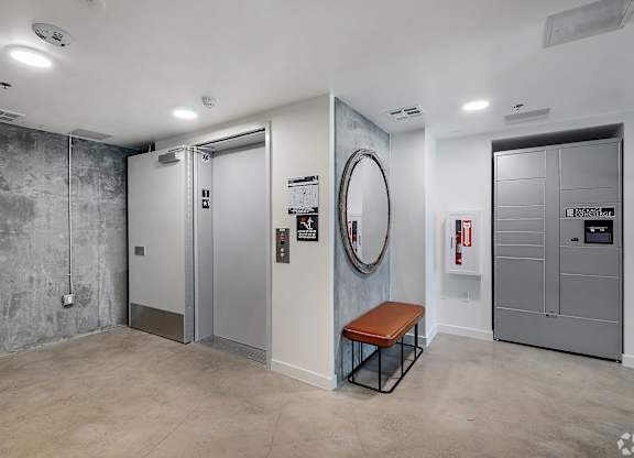 A room with a bench, a mirror, and a fire extinguisher.
