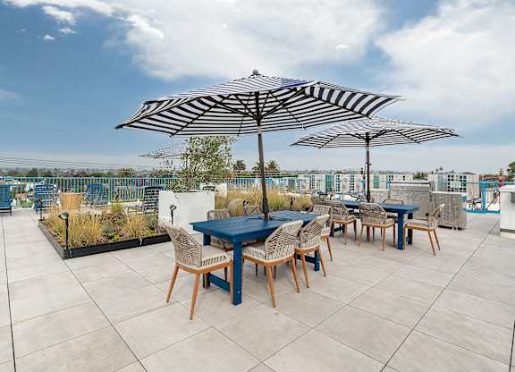 A patio with a table and chairs under umbrellas.