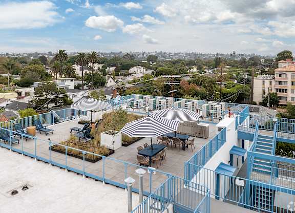 A rooftop patio with a striped awning and a staircase.