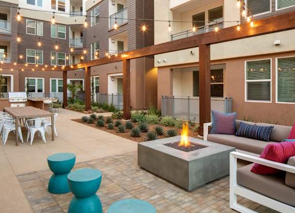 A patio with a fire pit and seating area.