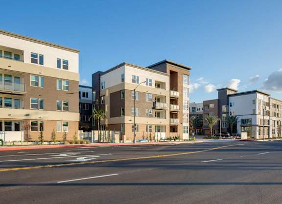 A row of modern apartment buildings line a street.