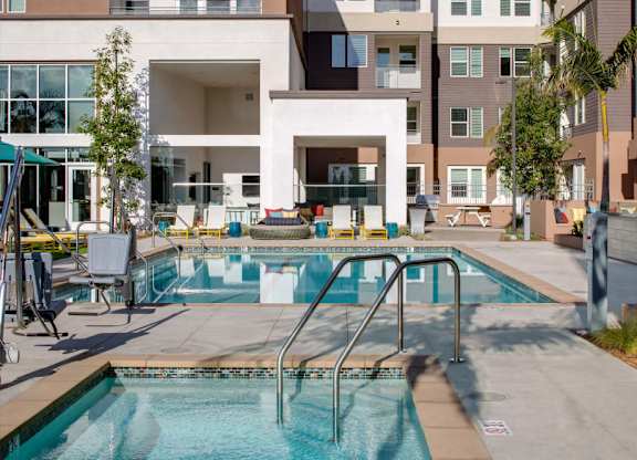 A swimming pool in front of a building with a white entrance.