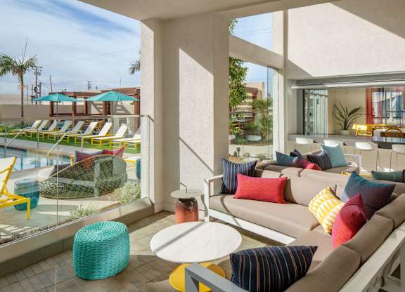 A sunny day at the poolside with a comfortable seating area.