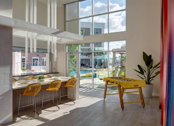 A brightly lit room with a yellow table and chairs.