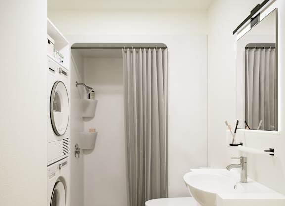 A white bathroom with a washer and dryer built into the wall.