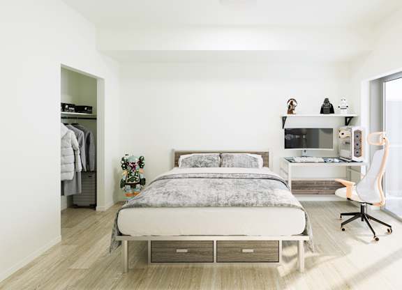 A bedroom with a bed, desk, and chair.