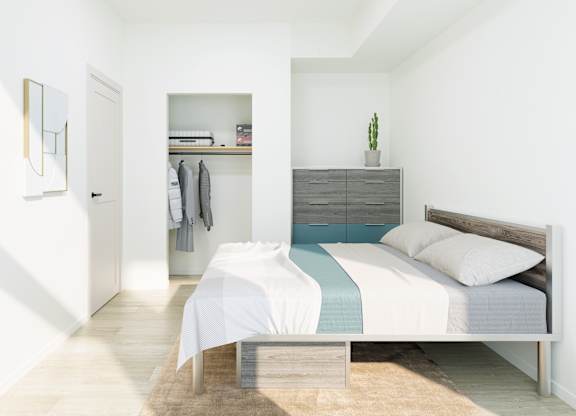 A bedroom with a bed, a wardrobe, and a mirror on the wall.