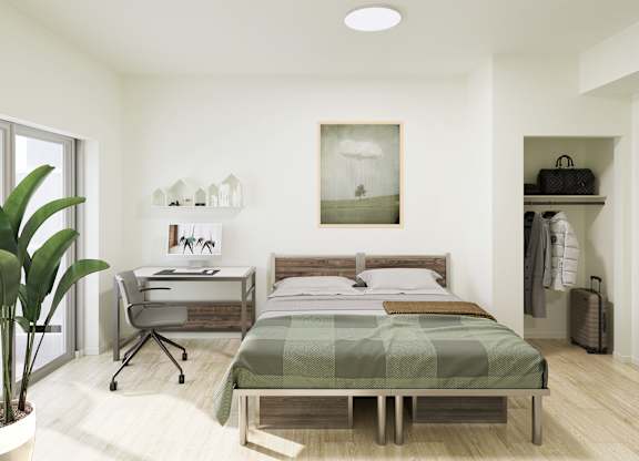 A bedroom with a bed, desk, and chair.
