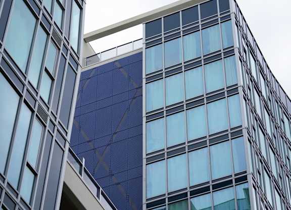 Two buildings with glass windows and a blue sky in the background.
