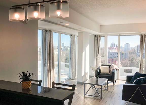 A living room with a view of the city through large windows.