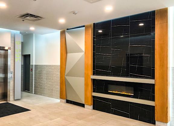 A modern hallway with a fireplace and a glass wall.