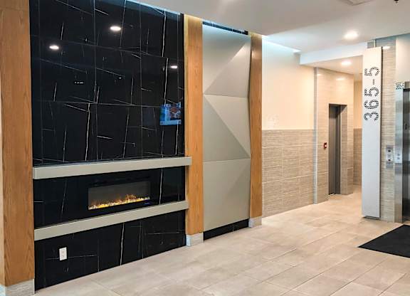 A hallway with a fireplace and a glass wall.