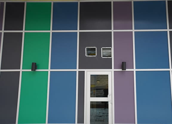a building with blue and green squares and a white door