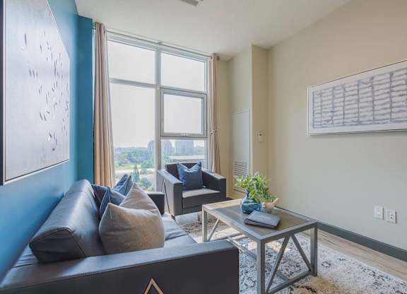 a living room with a couch and a table     and a window